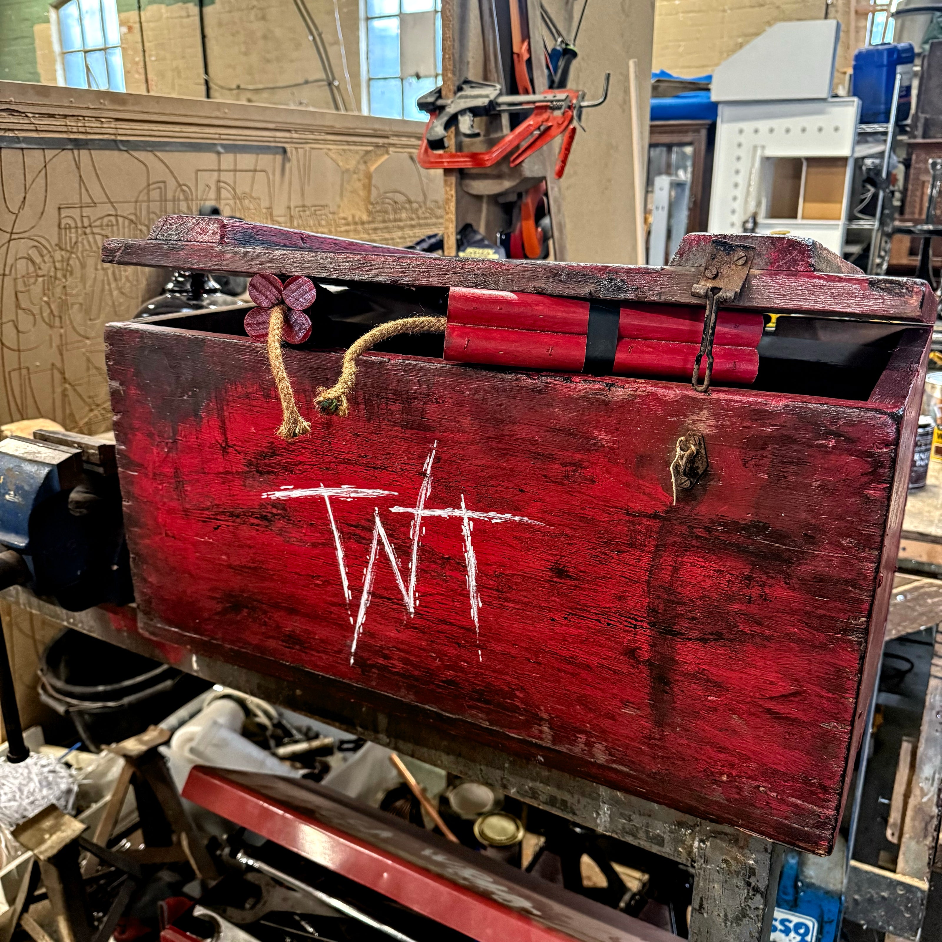 Red wooden box with 'TNT' marking in a workshop setting